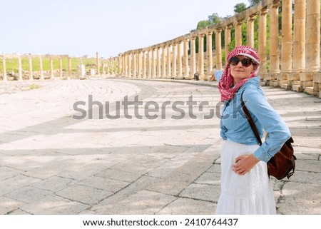 Jerash - jordan. travel tourism holiday background -young girl with hat standing pointing to Ancient Roman city of Gerasa of Antiquity, Jerash
