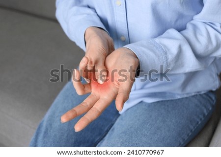 Woman suffering from trigger finger on sofa, closeup Royalty-Free Stock Photo #2410770967