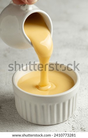 Fresh condensed milk in the bowl. Royalty-Free Stock Photo #2410773281