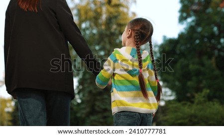 mother holding little daughter hand, family walking park sunset, mother parent holding palm finger child kid, city, fun, mommy make, assistance, children, giving, mother young, mom, one parent Royalty-Free Stock Photo #2410777781