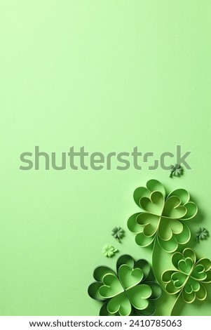 St Patrick's Day vertical banner or poster template with handmade paper cut clover decoration on green background. Royalty-Free Stock Photo #2410785063