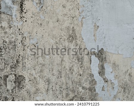 Old concrete wall with cracked flaking paint. Weathered rough painted surface with patterns of cracks and peeling. Great texture for background and design