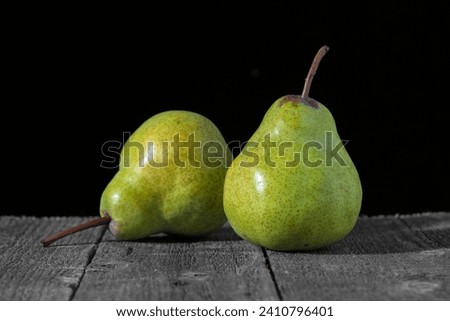 Pears on a wooden table on a black background