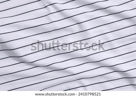 Striped baseball uniform as background, top view