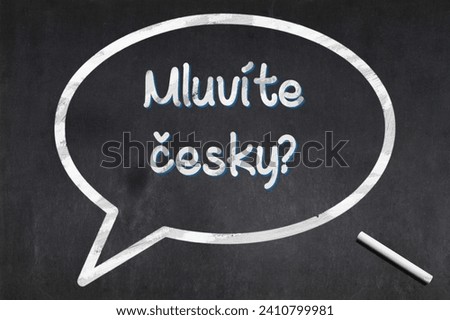 Blackboard with a bubble drawn in the middle with the short phrase in Czech "Mluvíte česky?", meaning "Do you speack Czech ?".