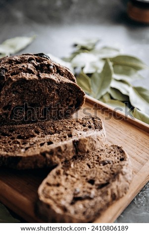 Wholemeal bread with dried cranberries and bay leaves on wooden board