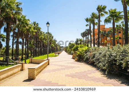 Seaside promenade with palm trees in Isla Canela, andalucia, Spain Royalty-Free Stock Photo #2410810969