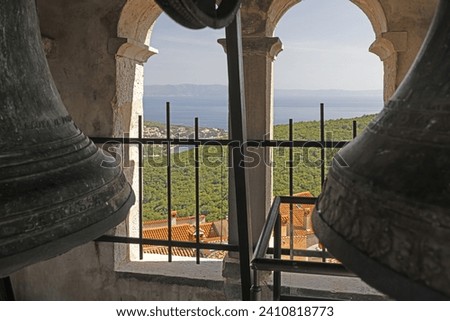 Picture of bronze bells in a bell tower of a historic church in Kratia during the day