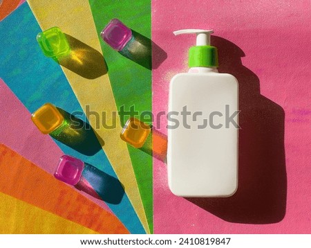 White jar with dispenser and green lid on background of colorful stripes