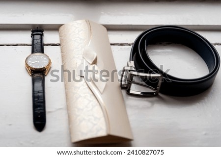 A captivating composition of a stylish watch, a custom-designed watch band, and an enchanting timepiece delicately poised on a table. Royalty-Free Stock Photo #2410827075