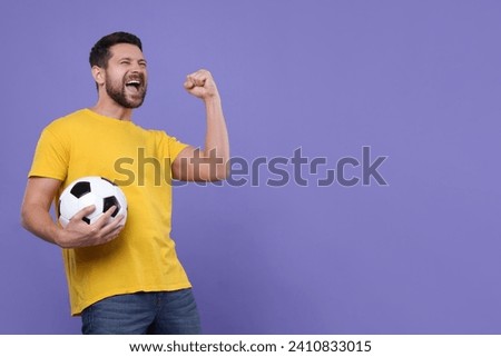 Emotional sports fan with ball celebrating on purple background. Space for text