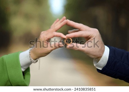 A wooden wedding. The bride and groom celebrate a wooden wedding. A man and a woman are holding two wooden wedding rings in their hands, close-up. A symbol of a wedding, five years of marriage.