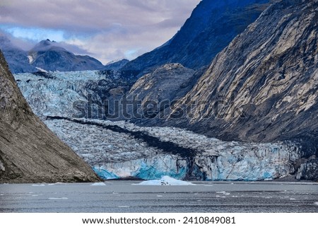 Inlets Iceberg Maker Is Nearly Gone. Retreating glaciers have changed how visitors experience Glacier Bay National Park in southeast Alaska. Elements of this image furnished by NASA. Royalty-Free Stock Photo #2410849081