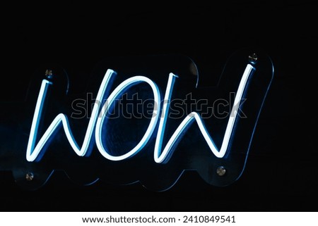 Wow. Neon electricity fluorescent sign “Wow” concept illuminated vintage retro club. Glow icon logo text light WOW on billboard or signboard. Closeup