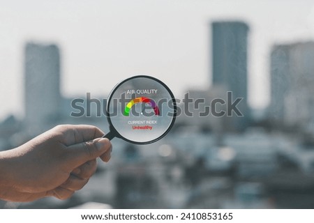 Hand holding a magnifying glass to check the air quality for PM 2.5 over smog city from PM2.5 dust on background low visibility city with dangerous haze and fog. health care, pm 2.5 warning Royalty-Free Stock Photo #2410853165