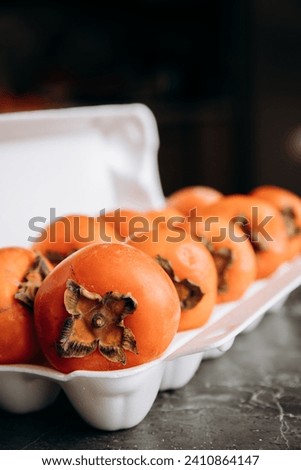 Ripe persimmons on a dark background, selective focus.