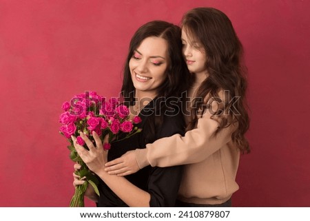 Beautiful dark-haired girl with a bouquet of small pink roses on a pink background