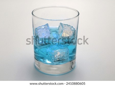 Aqua blue cocktail drinks with flashing led neon vibrant sparkling ice cubes background