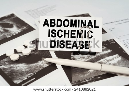 Medical concept. On the ultrasound pictures there is a pen and a business card with the inscription - abdominal ischemic disease