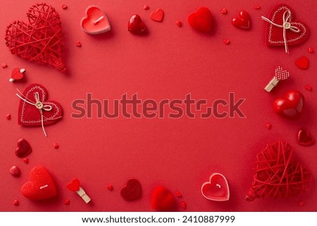 Captivating top view of Valentine's revelry, boasting creative decor: top view clothespins, candlelit charm, rattan hearts, sprinkles on rich red background. Strategic space for text or promo content Royalty-Free Stock Photo #2410887999