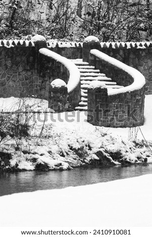 Snow covered steps lead down to Monocacy Creek at Monocacy Park in Bethlehem, Pennsylvania.  January 2024