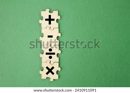 wooden puzzle with plus, minus, division and multiplication signs. mathematics learning concept Royalty-Free Stock Photo #2410911091