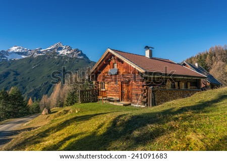 old wooden hut cabin in mountain alps at rural fall landscape Royalty-Free Stock Photo #241091683