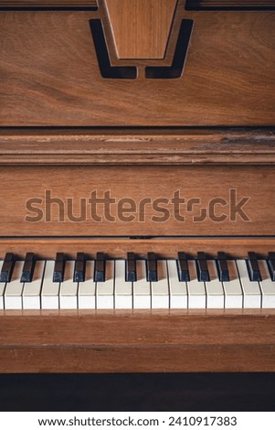 Piano keys on wooden brown musical instrument.