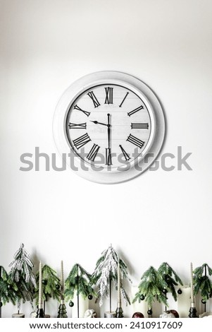White clock on a white wall in the interior.