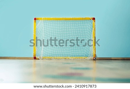 Children sport goal with empty net placed in gym for playing futsal or mini football indoor.