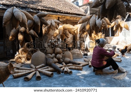 View of Vietnamese craftsman making the traditional bamboo fish trap or weave at the old traditional house in Thu sy trade village, Hung Yen, Vietnam, traditional artist and travel concept