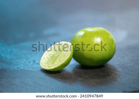 close up fresh lime, lemone in studio light on black stone plate in the kitchen. Royalty-Free Stock Photo #2410947849