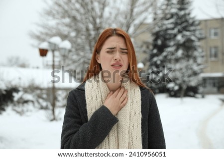 Beautiful young woman coughing outdoors. Cold symptoms Royalty-Free Stock Photo #2410956051