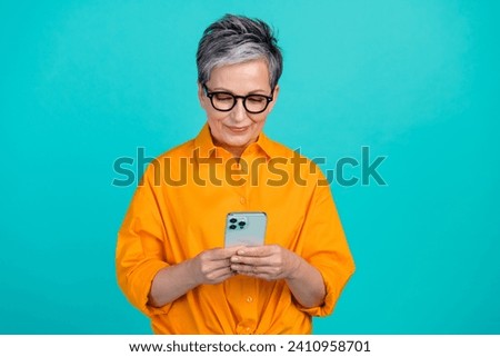 Photo of gray haired mature aged business woman texting colleagues to ask sources for research info isolated on cyan color background