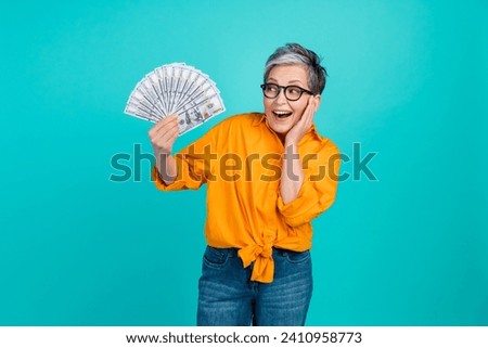 Photo of excited funny retired businesswoman receive extra pensioner money bonus for hard working isolated on aquamarine color background