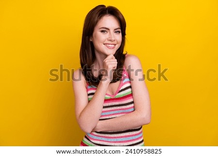 Photo of clever minded nice girl with stylish hairdo wear striped tank finger on chin think business isolated on yellow color background