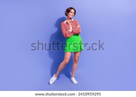 Full length photo of cool adorable pretty girl wear stylish shirt green skirt standing arms crossed isolated on blue color background