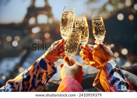 Bachelorette party. Close up shot of female hands holds glasses of sparkle wine in front of the main attraction in France. Travelling and relax. Concept of friendship, party, date, romantic, vacation.