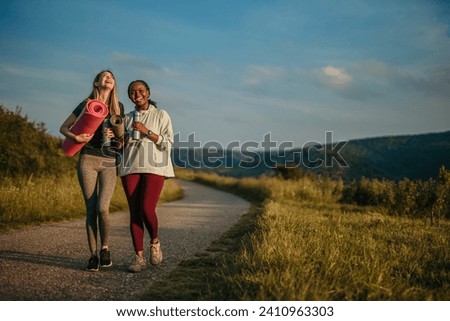 Strong and fit Caucasian woman alongside a confident and curvy Black woman embracing yoga in a natural setting