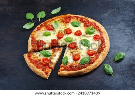 Traditional Neapolitan Italian pizza margherita with tomatoes and mozzarella served as close-up on an old rustic board with text free space 