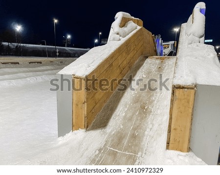 An ice slide made of boards, a playground for rides, a children's slide. High quality photo