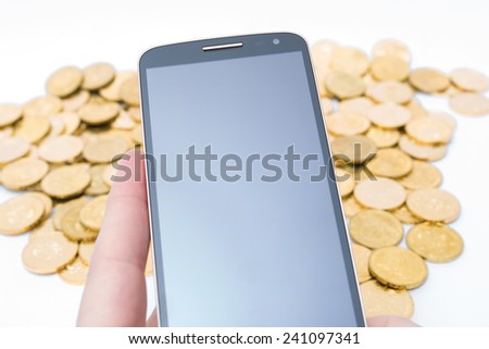 Cellphone with golden coins in the background