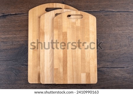 Three empty wooden cutting boards on a wooden background. Copy space.