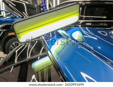 Removing dents on the car. PDR technology. Car body repair without painting. A specialist repairs a dent on the car body without painting.  Royalty-Free Stock Photo #2410991499