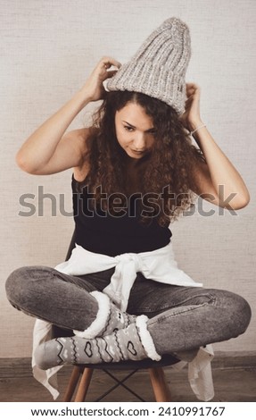 Teenage girl is sitting on a chair at home. A home photo shoot.