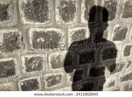 Shadow of a person on a stone wall in the morning