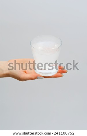Glass with water and effervescent tablet in a female hand