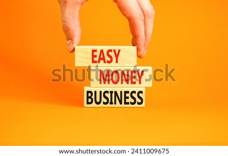 Easy money business symbol. Concept words Easy money business on beautiful wooden blocks. Beautiful orange table orange background. Businessman hand. Easy money business concept. Copy space.
