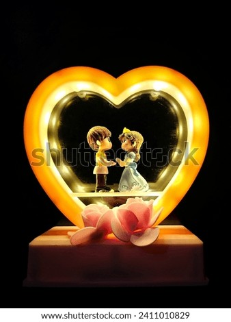 A Beautiful creative heart shaped love couple showpiece statue craft in night light. Royalty-Free Stock Photo #2411010829
