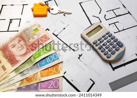 Close-up on some Swedish krona (SEK) banknotes, a home key and a calculator on the top of building plans. Royalty-Free Stock Photo #2411014349